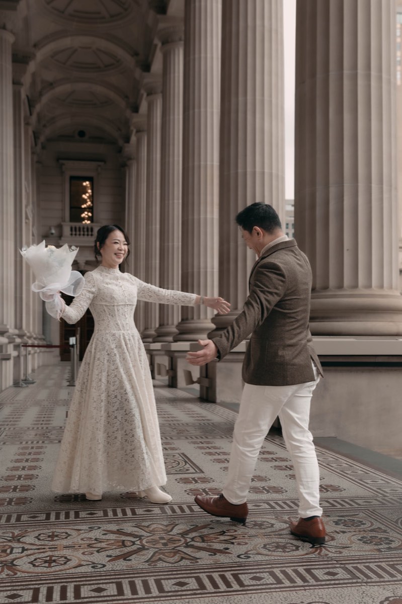 The couple dance between the columns of the colonnade