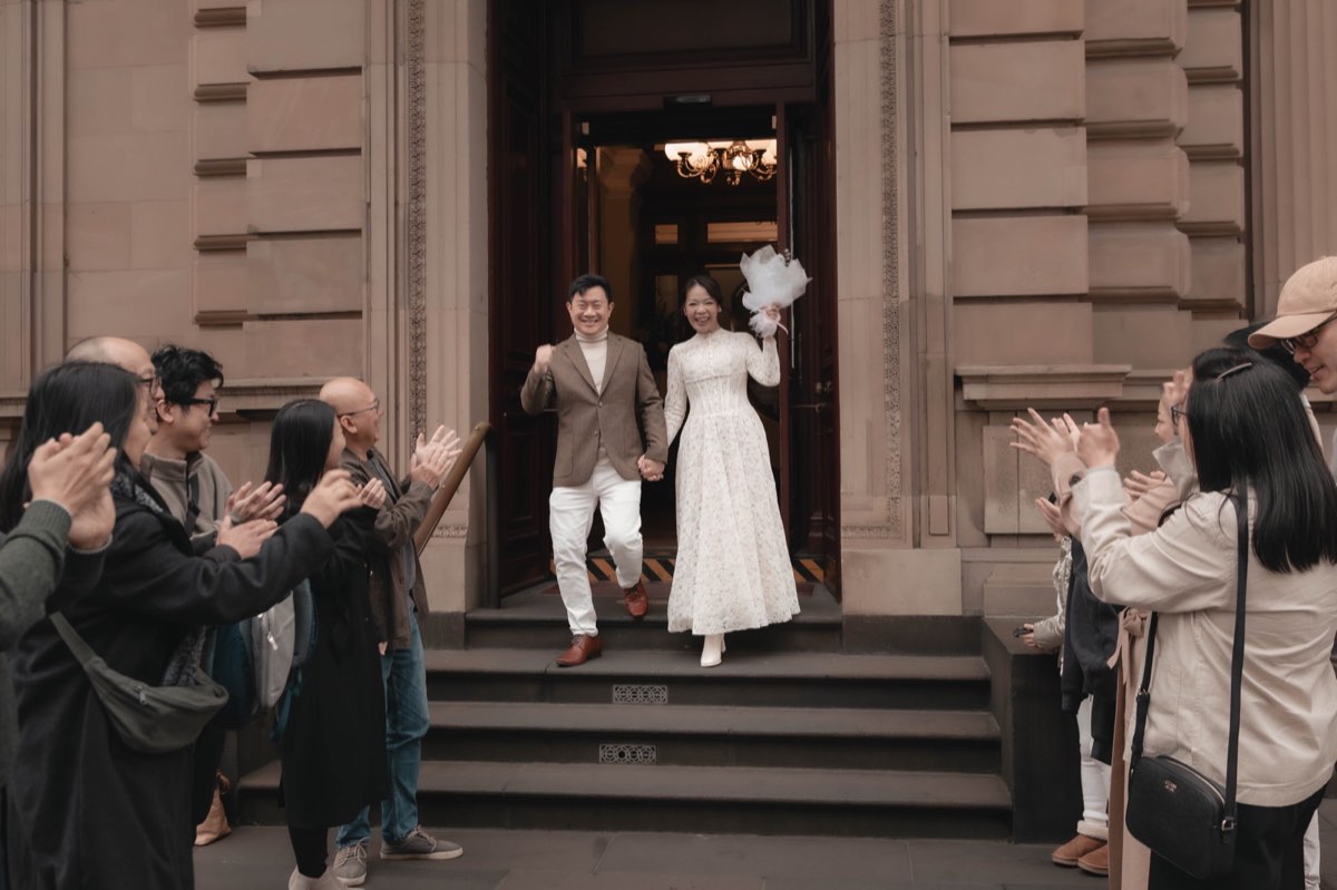 Guests applaud as the newlyweds come down the steps of the Old Treasury Building